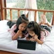 Little girls is looking at tablet on the bed. - VideoHive Item for Sale