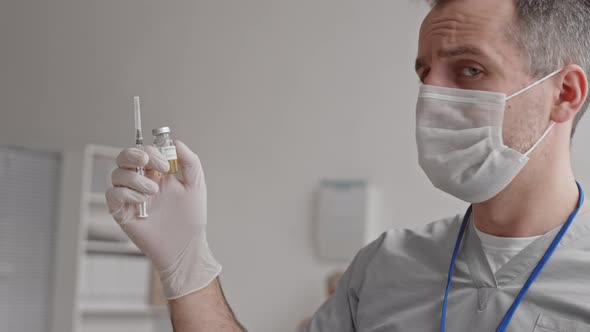 Doctor Holding Ampoule and Syringe