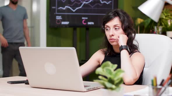 Manager Sits at the Computer, Looks at the Watch and Realise She Is Late for a Meeting