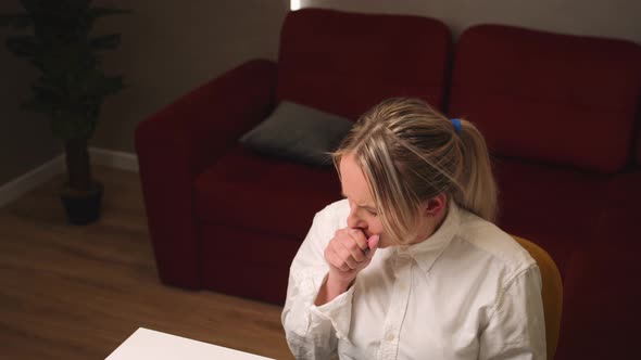 A Young Woman Coughing Work on a Laptop at Home Office