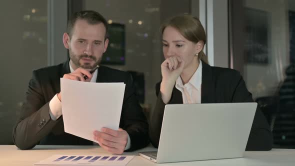 Executive Business People Discussing the Documents at Night