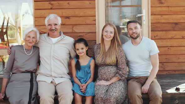 Portrait of Happy Big Family Embracing and Smiling on Wooden Porch