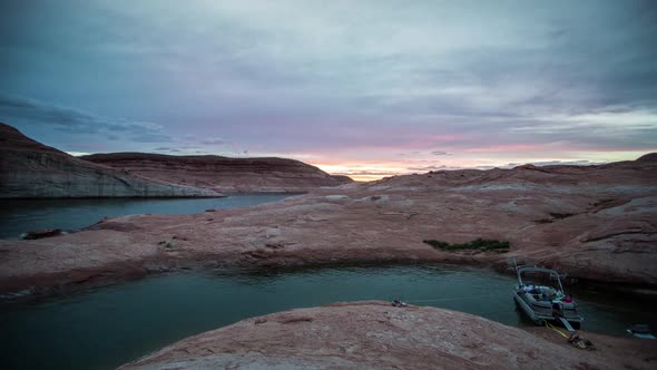 Time-lapse during sunset at Lake Powell with a boat and person on the shore.