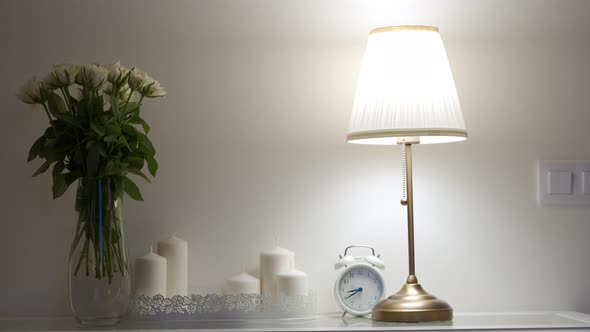 Console Table with Bouquet of Flowers Lit By a Table Lamp in the Living Room Apartment Decoration