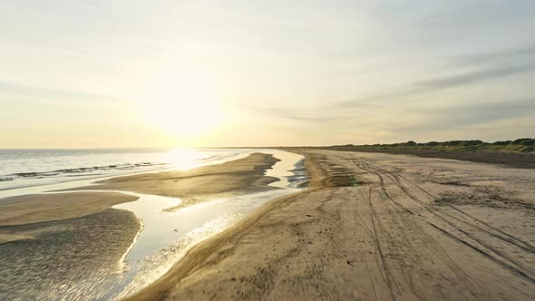 Drone Tracking Shot Along Beach in Denmark and Glare From Sun in the Background