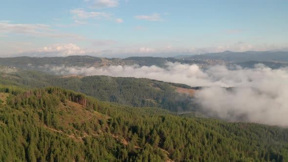 Drone flight over low clouds and morning mists