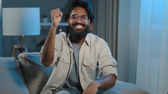 Close Up Happy Indian Arabian Bearded Man Football Male Fan Sitting at Home Evening at TV Screen in