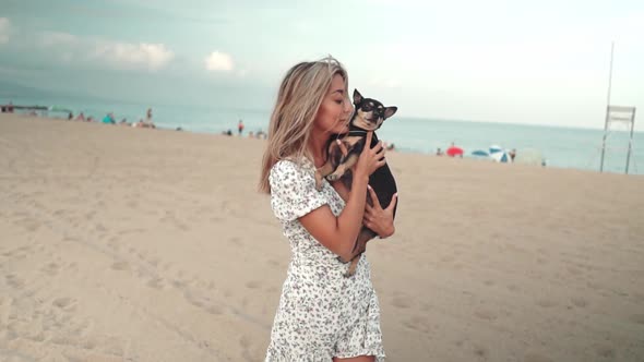 Small Dog Named Artur with Owner, Young Woman, Playing on the Beach