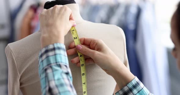 Seamstress Takes Measurements From Mannequin in Atelier