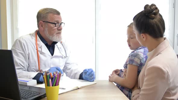 Little Girl with Her Mother at a Pediatrician Appointment. The Child Is a Little Scared. An