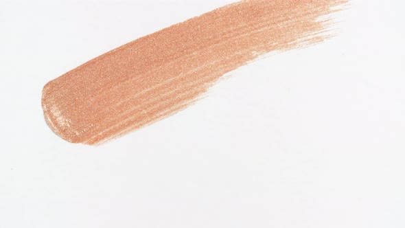 Macro Shot and Slow Motion of a Brush Applicator Smear Concealer Isolated on White Background