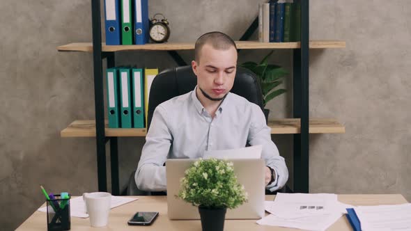 Young Man Doing Paperwork in Office