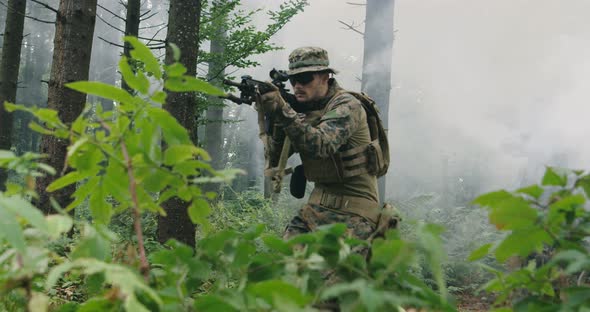 Soldier Moving Through Smokey Forest with Rifle Ready to Shoot Running Through Forest During