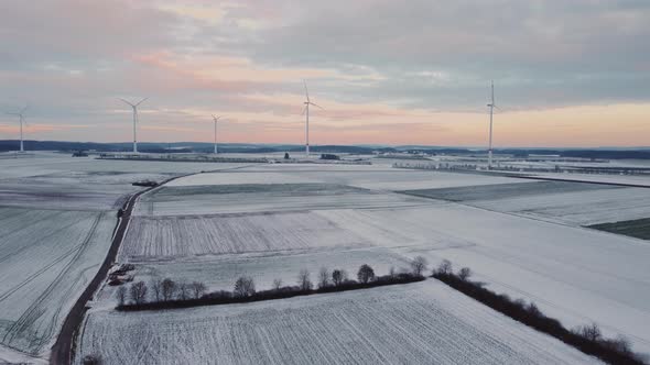 4K Droneflight moody sky with wind turbines in nature