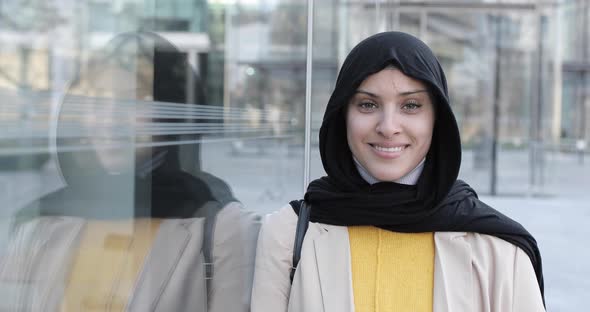 Attractive smiling woman wearing hijab and looking at camera