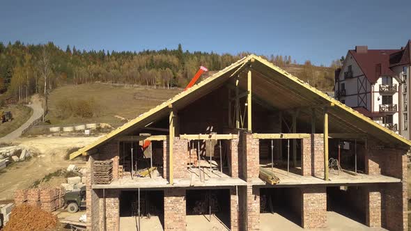  Wooden frame of new roof on a brick big house under construction.
