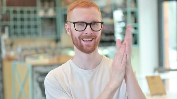 Portrait of Cheering Redhead Man Clapping