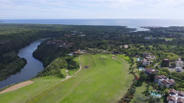 Aerial drone landscape view of a golf course and luxury resort near a river, Dominican Republic