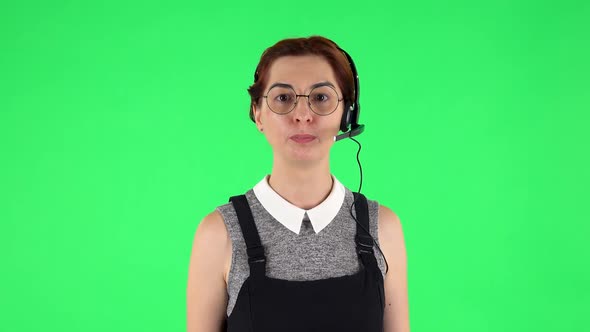 Portrait of Funny Girl in Round Glasses with Headset Helping with Customer Service and Worry. Green