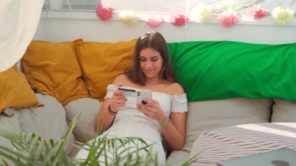 Smiling woman making purchase during online shopping via smartphone