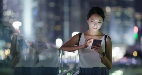 Woman use of mobile phone in city at night