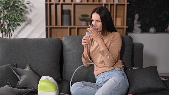 Unhealthy Caucasian Woman with an Inhaler Doing Inhalation at Home She Use Nebulizer and Inhaler for