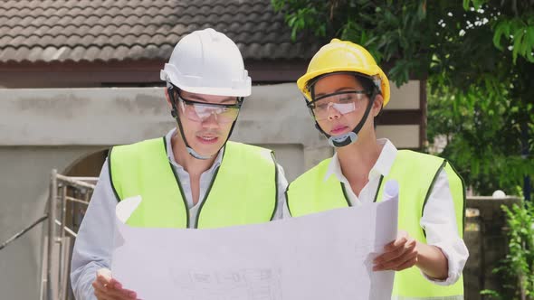 Asian colleague workers people wearing protective safety helmet and glasses onsite of architecture