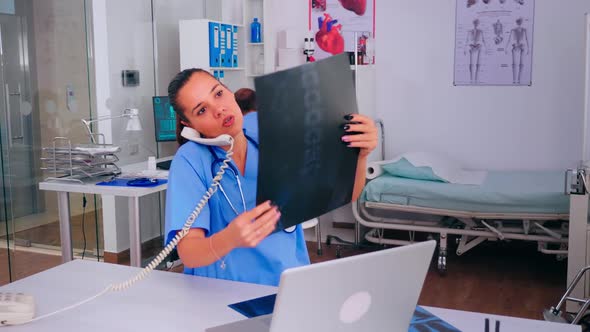 Nurse Receptionist Answering at Hospital Call Holding Xray