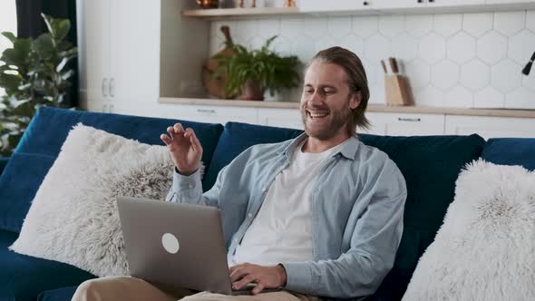 Smiling Man Looking at the Screen Delighted with Satisfying Results or Achievements