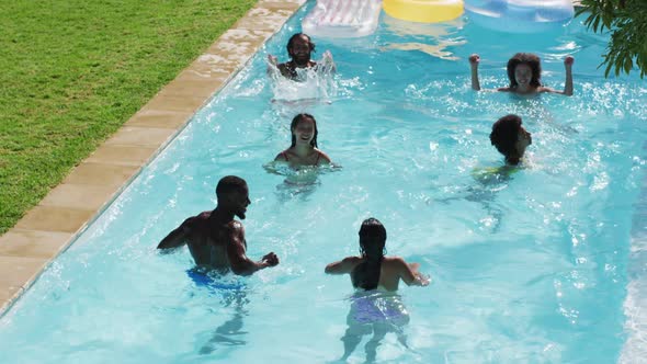 Diverse group of friends having fun playing in swimming pool