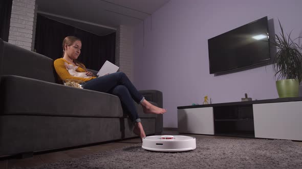 Young Female Enjoying Free Time on Sofa with Pet