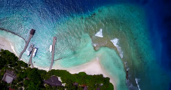 Wide angle drone copy space shot of a white paradise beach and blue water background in vibrant 4K