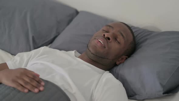 African Man Coughing While Awake in Bed Close Up