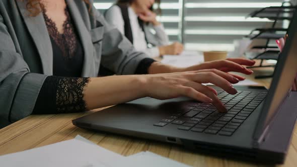 Close up businesswoman hands typing on laptop working online in office.