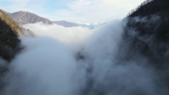 Drone View of the Dense Fog Creeping Along the High Cliffs in the River Valley