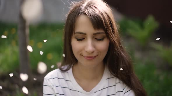 Petals From the Tree Fall on the Young Woman