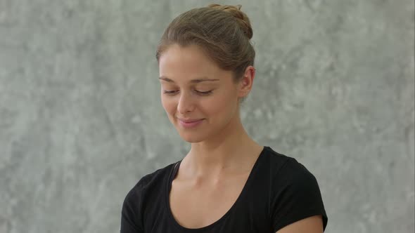 Young Female Trainer Doing Namaste Pose and Smiling, Welcome Group Before Yoga Class