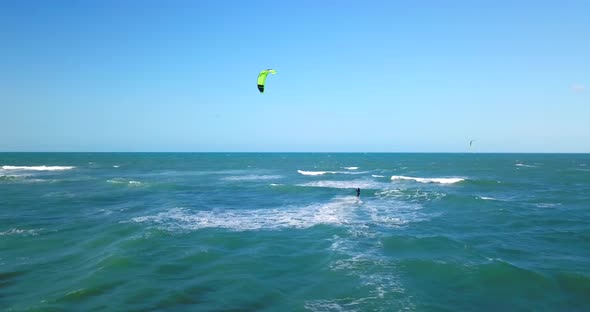 Aerial drone view of a man kiteboarding on a kite board.