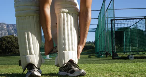 Cricket player tying his batting pads during a practice session