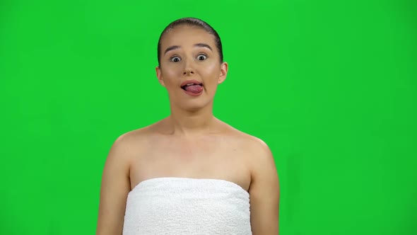 Brunette Woman in White Towel Makes Funny Faces on Green Screen at Studio