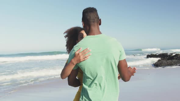 African American couple dancing seaside