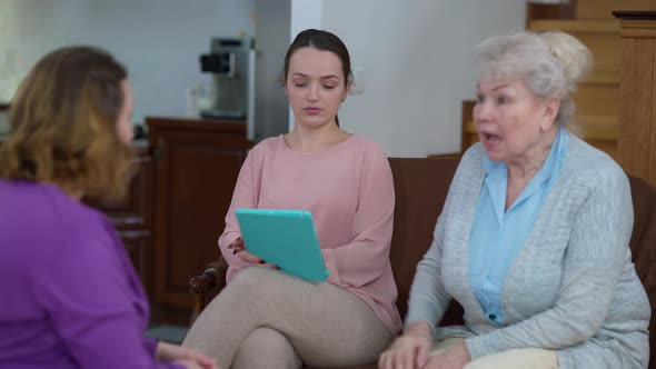 Portrait of Young Beautiful Slim Woman Surfing Social Media on Tablet Ignoring Family Arguing at