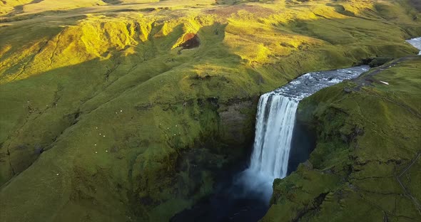 Skogafoss waterfall from air during sunrise