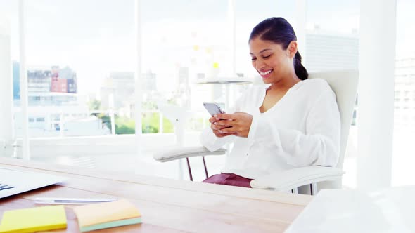 smiling Woman using smartphone in office