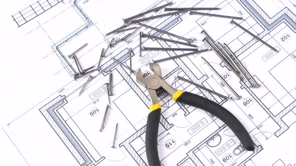 Wire Cutters with Yellow, Gray Handle on Building Plan, Scheme, Among Nails, Rotation