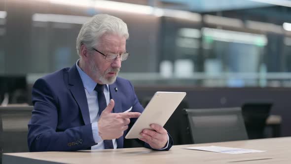 Old Businessman Making Video Call on Tablet at Work