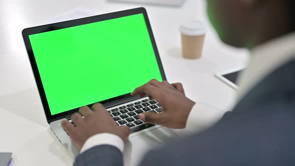 Rear View of African Businessman Using Laptop with Chroma Key Screen