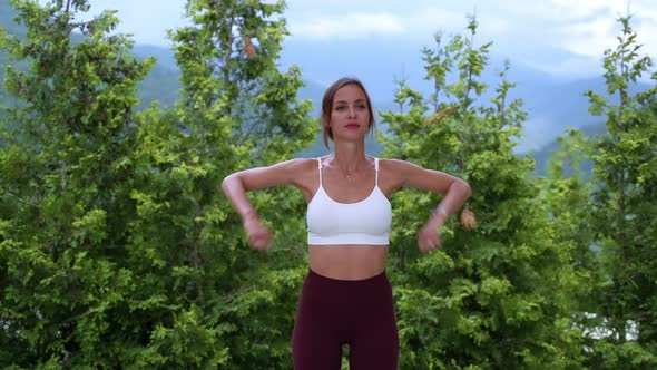 Sporty Woman is Training Alone in Park Rotating Arms Warming Body Before Workout