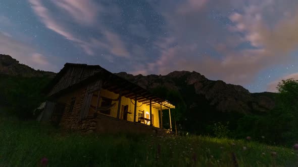 Moving clouds in night sky andromeda in milky way galaxy and starry night over a wild hut in Forest