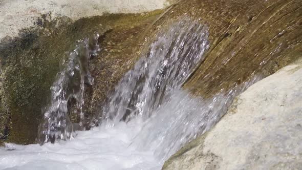 Closeup View of Water Flows Down Large Stones